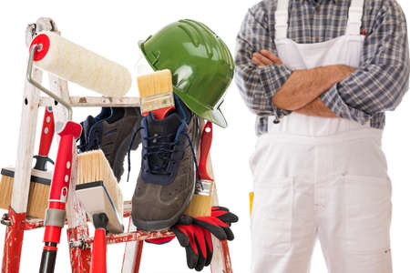 Work tools and safety equipment for professional house painter on a sturdy metal ladder. House painter in the background. Isolated on white background.の写真素材