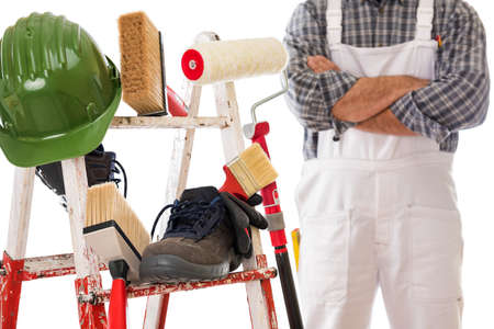 Work tools and safety equipment for professional house painter on a sturdy metal ladder. House painter in the background. Isolated on white background.の写真素材