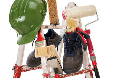 Work tools and safety equipment for professional house painter on a sturdy metal ladder. Isolated on white background.の写真素材