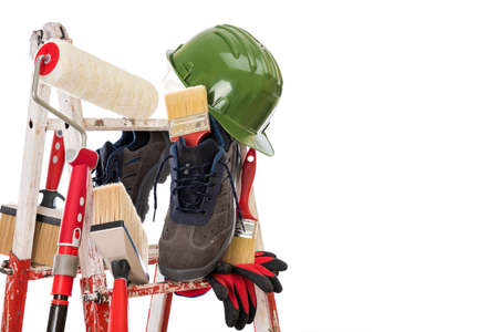 Work tools and safety equipment for professional house painter on a sturdy metal ladder. Isolated on white background. Text space.の写真素材