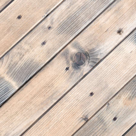 Texture of the planks of an old wooden table in warm colors fixed with bronze colored screws. Vintage rustic wooden background.の写真素材
