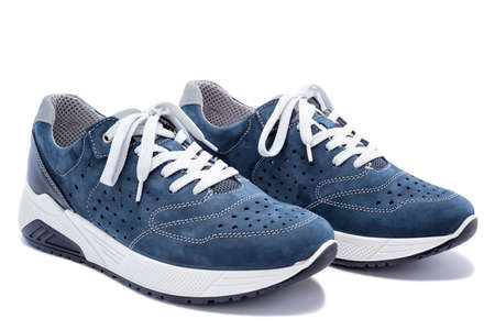 Close up of elegant light blue sports shoes in natural nubuck leather for adult men photographed on a white background. Fashion accessories.の写真素材