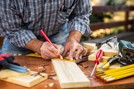 Adult carpenter with a pencil and square carpenter. Construction industry, housework do it yourself. Stock photography.の写真素材