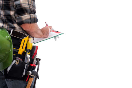 Rear view of a carpenter isolated on white background, writes work notes on a notebook. Work tools industry construction and do it yourself housework. Stock photography.の写真素材