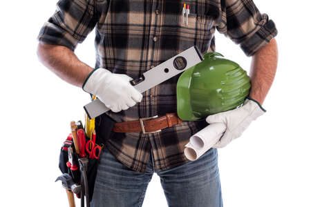 Carpenter isolated on a white background, he wears leather work gloves. He is holding the level, the helmet and the work project. Work tools industry construction and do it yourself housework. Stock photography.の写真素材