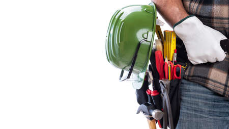 Carpenter isolated on a white background; he wears leather work gloves, he is holding his helmet and...
