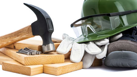 Close-up of a carpenter's hammer, helmet, goggles and protective gloves on a white background. Industry construction, work safety.の写真素材