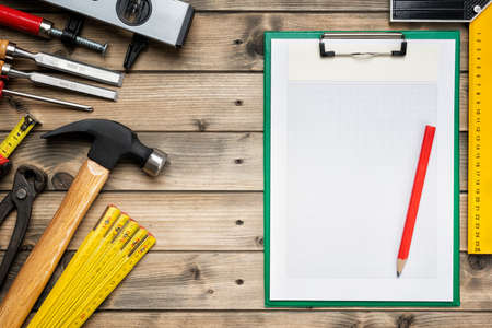 Top view to the carpenter's tools and notebook for notes on an antique wooden table. Construction industry, do it yourself. Wooden work table.の写真素材
