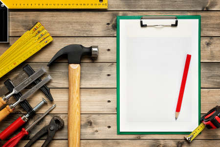 Top view of carpenter work tools and notebook for notes on an antique wooden table. Construction industry, do it yourself. Text space.の写真素材