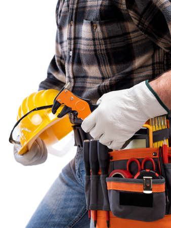 Electrician holds wire stripper plier in hand, helmet with protective goggles. Construction industry, electrical system. Isolated on a white background.の写真素材