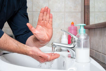 Coronavirus prevention. Hand washing with hot soapy water stops the infection from Covid-19, ALT sign with hand. Personal hygiene. Health.の写真素材