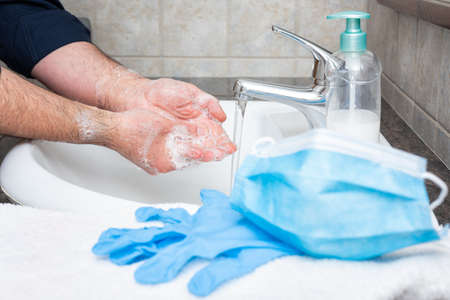 Hand washing with hot soapy water, the use of the mask and gloves stops the infection from Covid-19の写真素材