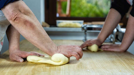 Close-up of woman's hands working the dough to prepare cheese ravioli. Traditional Sardinian cuisine.の写真素材