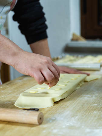 Close-up of woman's hands working the dough to prepare cheese ravioli. Traditional Sardinian cuisine.の写真素材