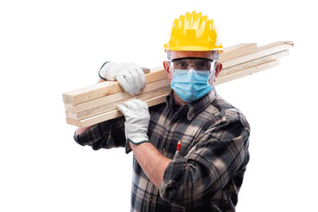 Carpenter worker isolated on white background, wears helmet, goggles, leather gloves and surgical mask  at the workplace.の写真素材