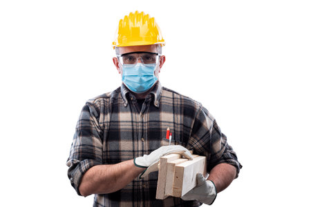 Carpenter worker isolated on white background, wears helmet, goggles, leather gloves and surgical mask   at the workplace.の写真素材