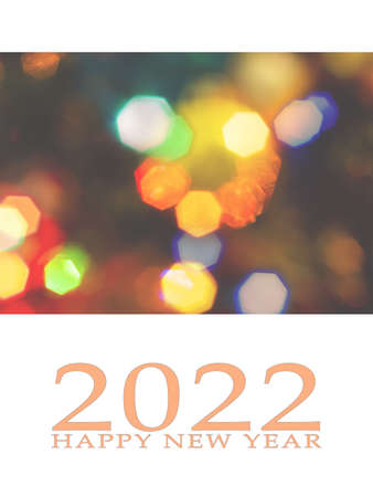 Happy New Year 2022 greeting card, blurred background of the twinkling lights of the Christmas tree. Greeting card background.の写真素材