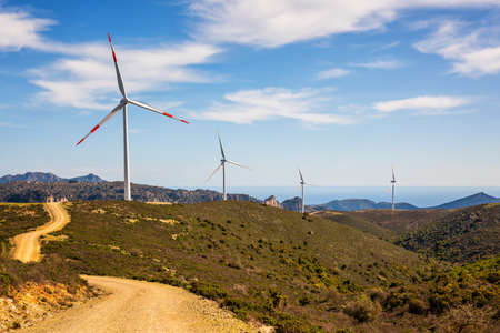 Wind turbines on a beautiful blue sky with clouds in a mountain wind farm in Sardinia. Renewable energy concept, green energy generation. Energy industry.の写真素材