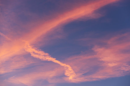 Landscape of a beautiful blue sky with clouds and white vapor trails at sunset. Nature.の写真素材