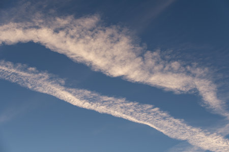 Landscape of a beautiful blue sky with clouds and white vapor trails in the evening. Nature.の写真素材