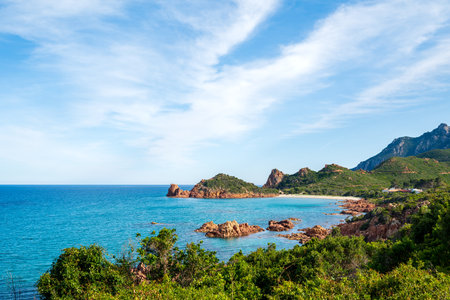 View from above of a stretch of the Eastern Coast of Sardinia in Ogliastra. Panorama of a pristine blue sea, surrounded by wild mountains covered with green vegetation. Uncontaminated landscapes.の写真素材