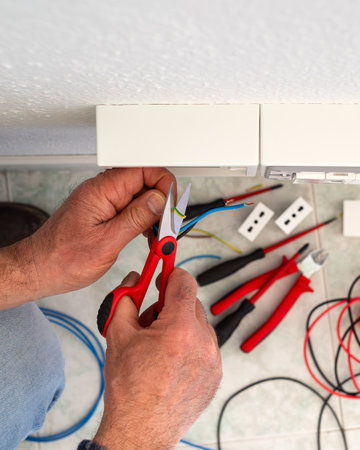 Electrician worker at work with scissors prepares the electrical cables of an electrical system. Construction industry.の写真素材