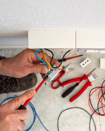 Electrician worker with screwdriver fixes electrical wires in the terminals of the socket of an electrical system. Construction industry.の写真素材