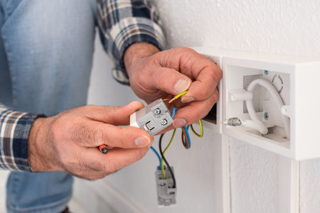 Electrician worker inserts electrical cables into the socket terminals of an electrical system. Construction industry.の写真素材