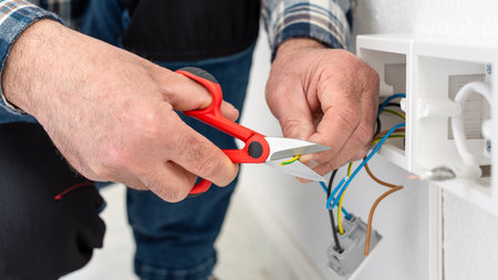 Electrician worker at work with scissors prepares the electrical cables of an electrical system. Construction industry.の写真素材