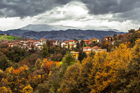 Scenic view of italian countryside medieval village against autumn foliage during a cloudy day, Vercallo, Reggio Emilia,の写真素材