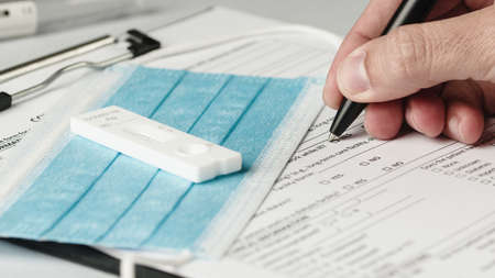 doctor writes covid swab results on medical record