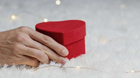 red heart shaped gift box on white carpet