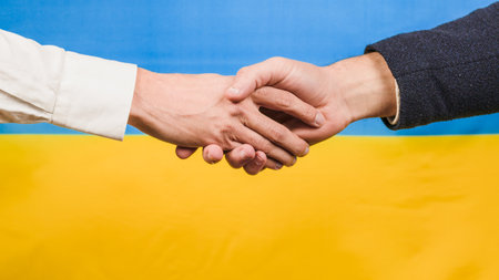 Peace agreement, handshake with ukrainian flag in backgroundの写真素材