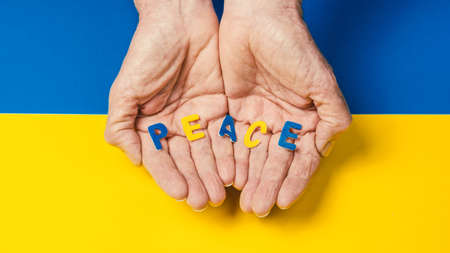 man holding a peace inscription in the colors of the ukrainian flag