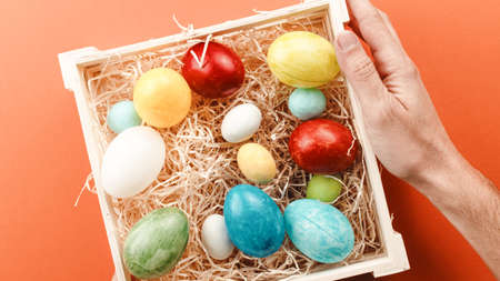 hand with basket of painted easter eggs