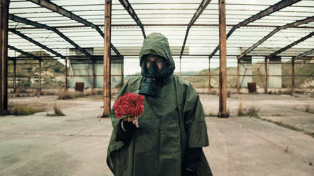 Soldier with bunch of red flowers and gas maskの写真素材