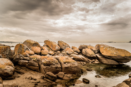 Rocks in Insuela, Palmeira, in the city of Riveira, Galicia (Spain). in the august morning cloudy day in the beautiful Ria de Arousa. I would like to have less than 20mm lense, but that's all I got.の写真素材