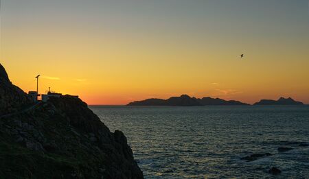 Sunset at Monteferro lighthouse in Nigran, Galicia, Spain, with Cies islands on backgroundの写真素材