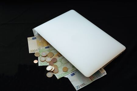 laptop with money on black backgroundの写真素材