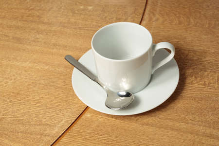 Empty white cup and saucer on wooden backgroundの写真素材