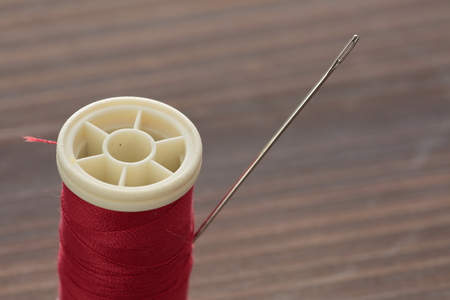 hand sewing needle with red thread bobbin