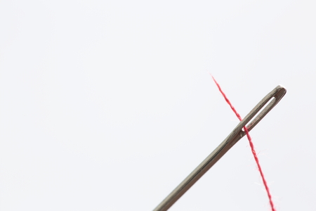 hand sewing needle with red thread bobbinの写真素材