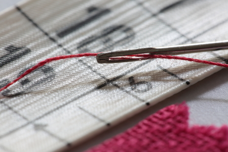 hand sewing needle with red thread bobbinの写真素材
