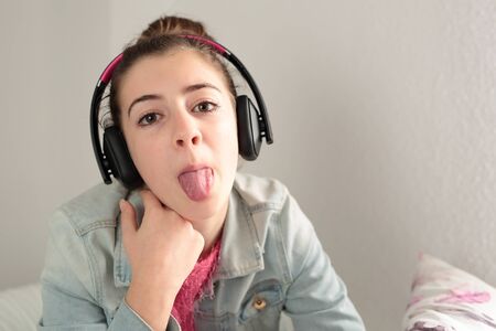 teenager listening to music with headphones in Senta Given in the bed of your room