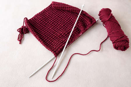 crochet needles and wool on a beige background