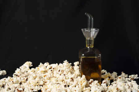 popcorn with oil in glass on black backgroundの写真素材