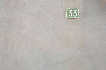 smooth gray wall with the number thirty-three on the top rightの写真素材
