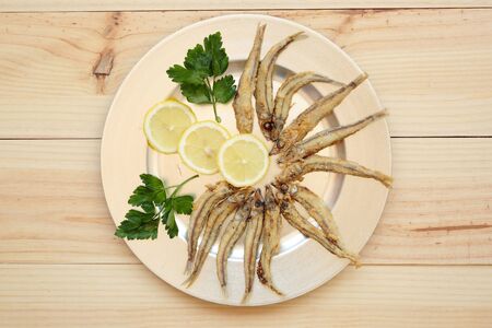 Fried fish with lemon on a silver trayの写真素材
