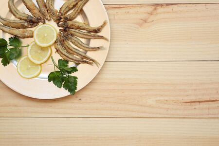 Fried fish with lemon on a silver tray