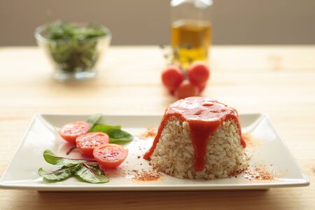 Cuban style rice decorated with cherrys tomatoes and a green leavesの写真素材
